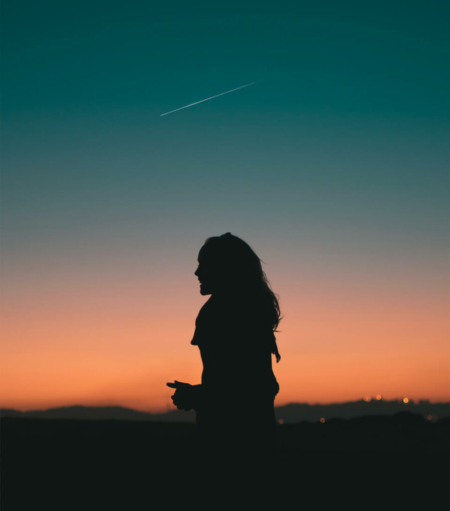 Silhouette de femme devant un coucher de soleil
